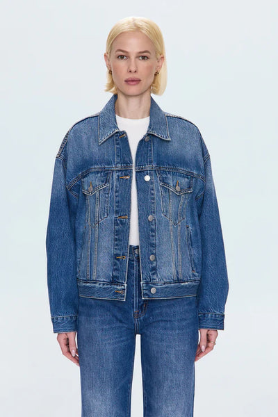 Person wearing a blue denim jacket and jeans on a light gray background